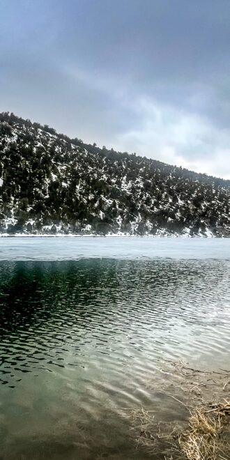Photo from shore at Cave Lake, showing newly reconstructed dam in the distance