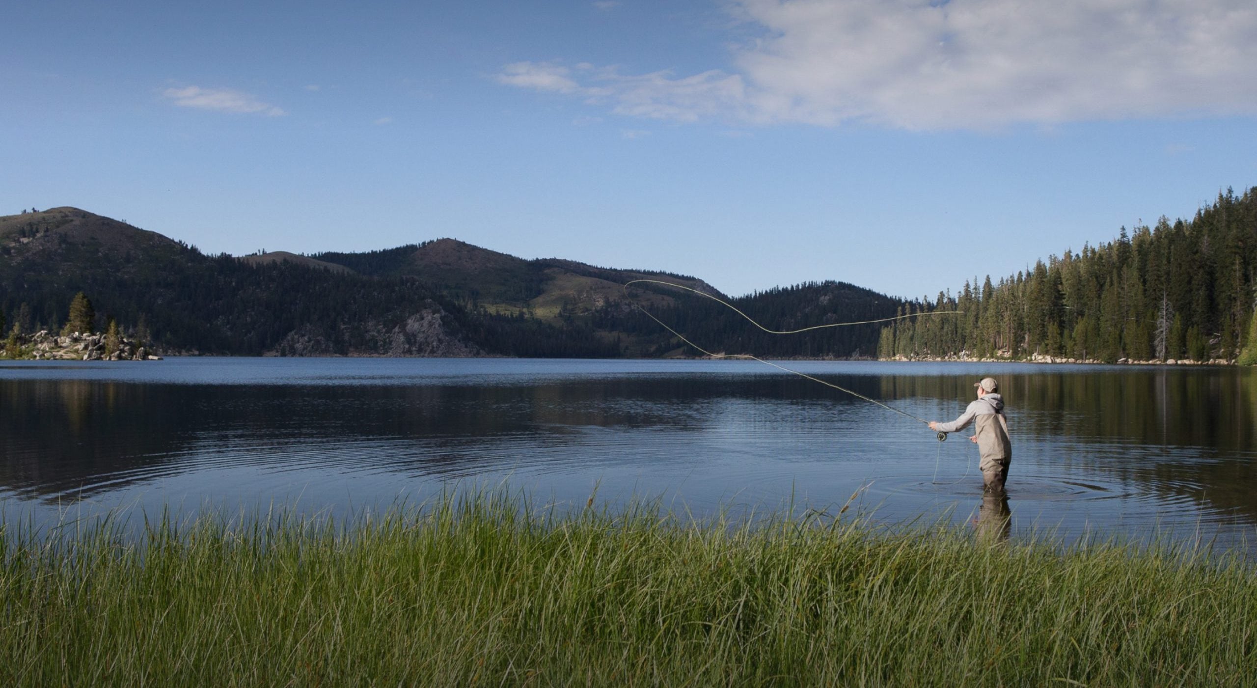 Fly fisherman casts a line at a Nevada alpine lake.