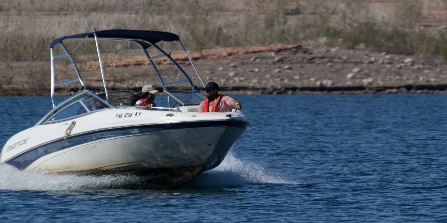 Speed boat on Lake Mead with man and woman sitting at the front of it.
